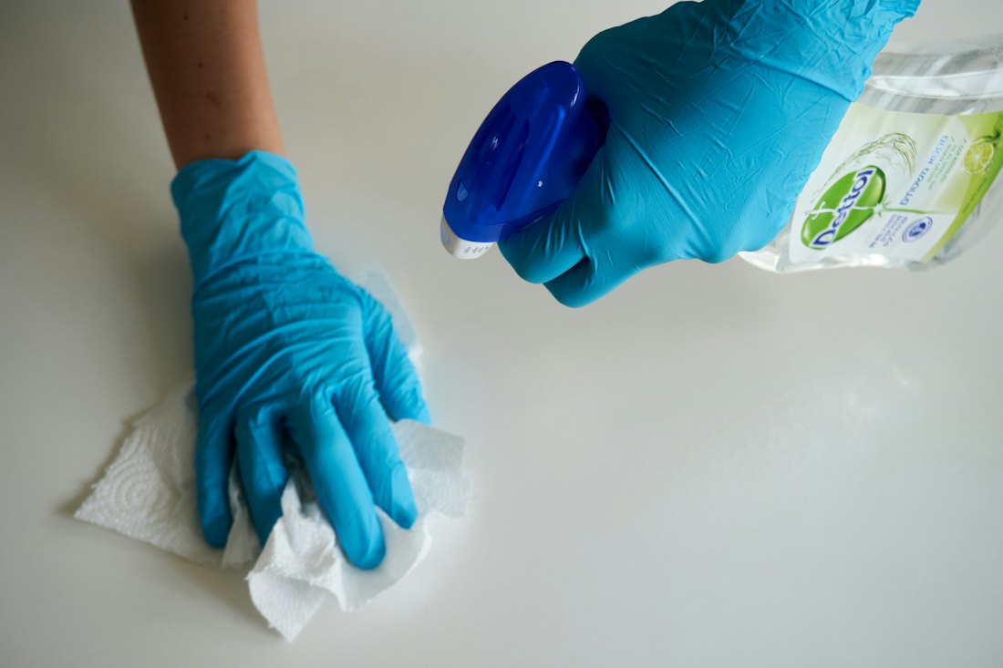 Eco-friendly cleaner holding non-toxic plant-based cleaning spray