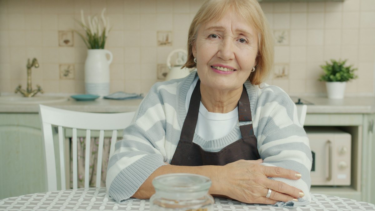 Smiling senior woman at her clean kitchen table
